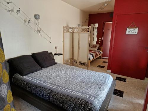 um quarto com uma cama e um armário vermelho em Appartement Le Dauphin 