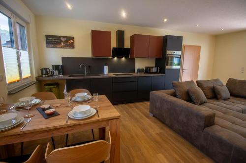 Una sala de estar con un sofá y una mesa y una cocina. en Ferienwohnung Philipp, en Traben-Trarbach