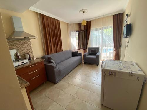 uma cozinha e uma sala de estar com um sofá e uma mesa em Tulip Apart Hotel em Ortaca