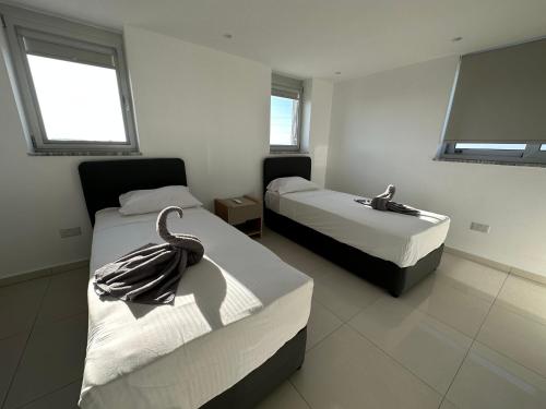 een hotelkamer met 2 bedden en handdoeken erop bij Valerian Palm Villas in Ayia Napa