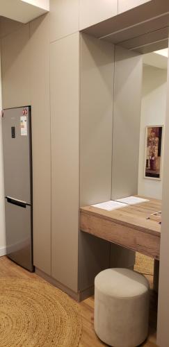 a room with a counter with a refrigerator and a stool at Cozy Urban Retreat in Almaty