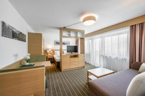 a living room with a couch and a television in a room at Apart Hotel Garni Wieser in Sölden