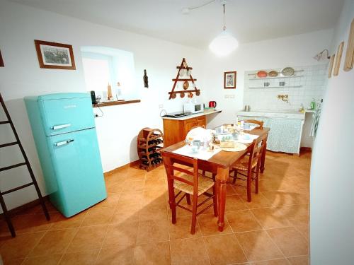 een keuken met een tafel en een blauwe koelkast bij Ca' du Tu in Masone