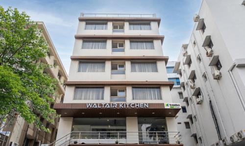 a tall building with a walker kitchen sign on it at Treebo Trend PL Grand Vishakapatnam in Visakhapatnam