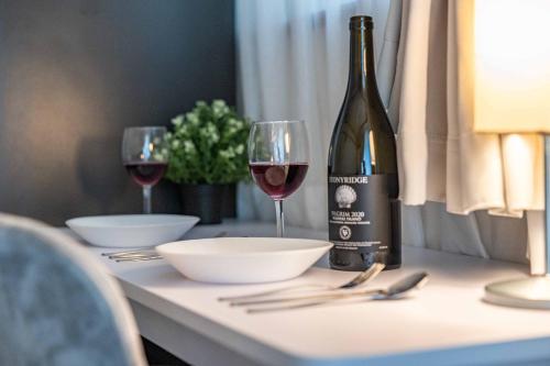 a bottle of wine and two glasses on a table at エステラス大阪ウエスト102 in Osaka