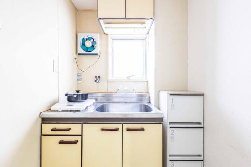 a small kitchen with a sink and a window at エステラス大阪ウエスト102 in Osaka