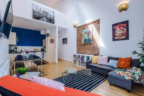 a living room with a couch and a kitchen at LARGE DUPLEX Apartment in CITY CENTRE! LIME STREET! FOOTBALL! Ideal for Stag and Hen Do Stays! in Liverpool