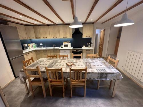 a kitchen with a table and chairs in a kitchen at Chalet familial de village en Savoie in Peisey-Nancroix