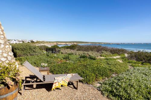 a table and a chair sitting on a beach at Paternoster Dunes Boutique Guesthouse in Paternoster