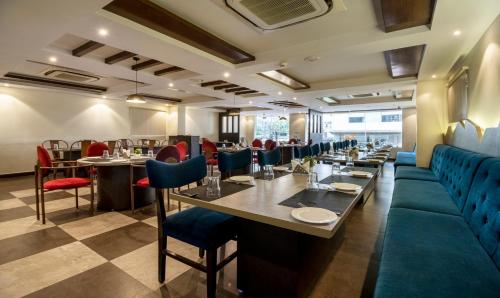 Un comedor con mesas y sillas azules. en Treebo PL Grand, Vishakapatnam, en Visakhapatnam