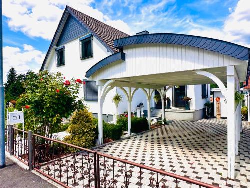 a white house with a gazebo at Ferienhaus zur Waldauer Höhe mit 3 SZ, 120qm & 40qm Balkon in Schleusingen