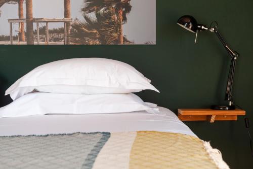 a bedroom with a bed with a green wall and a lamp at Cheese & Wine Lapa in Lisbon