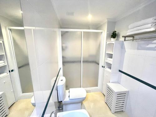 uma casa de banho branca com um WC e um chuveiro em RELAX VIVEIRO em Viveiro