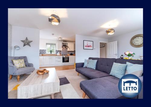 a living room with a couch and a table at Letto Serviced Accommodation Peterborough - Davis House - PE7 - FREE Parking in Peterborough