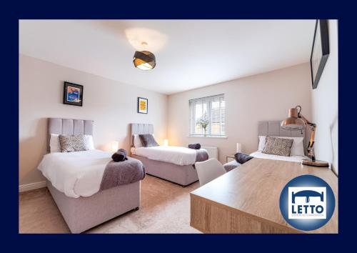 彼得伯勒的住宿－Letto Serviced Accommodation Peterborough - Davis House - PE7 - FREE Parking，一间带两张床和一张沙发的客厅