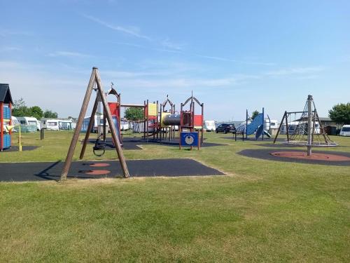 a park with a playground with a slide at Lake District Modern Static Caravan in Maryport