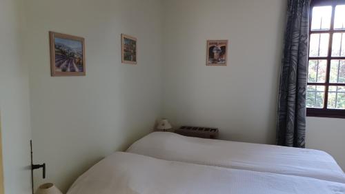 ベドアンにあるL' Homme de fer - gîte Kathyの白いベッドルーム(ベッド1台、窓付)