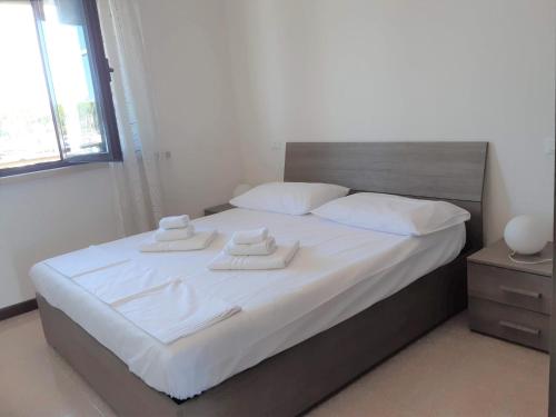 a bedroom with a bed with two towels on it at Villa a schiera con uso piscina in Aprilia Marittima