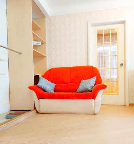 a red couch sitting in a living room at 2 кімнатні апартаменти в центрі Дніпра, поруч Мечнікова для ЗСУ знижка in Dnipro