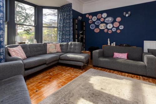 uma sala de estar com sofás e pratos na parede em St Marks Stays em Sedbergh