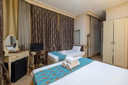 a hotel room with two beds and a mirror at Felicity Hotel İstanbul in Istanbul