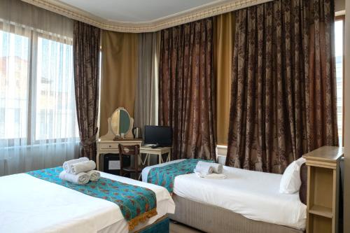 a hotel room with two beds and a television at Felicity Hotel İstanbul in Istanbul