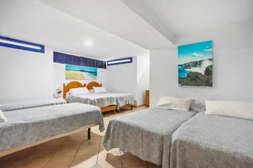 ein Schlafzimmer mit 2 Betten und einem Wandgemälde in der Unterkunft Villa Mariposas in Corralejo