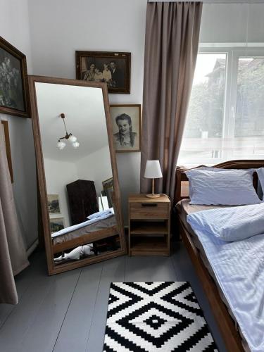 Un dormitorio con dos camas y un espejo. en Hudozhnyk, en Yaremche