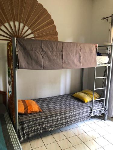 Ce lit superposé se trouve dans un dortoir doté d'une couchette supérieure. dans l'établissement À Pied Dans L'Eau, à Saint-Gilles les Bains