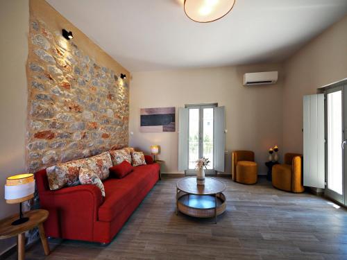 a living room with a red couch and a table at Terra Di Pietra Exclusive Suites & Apartments in Areopolis