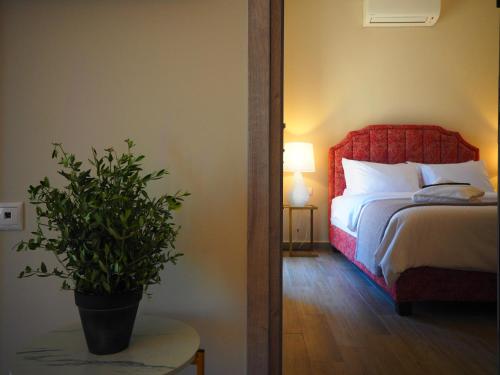a bedroom with a bed and a potted plant at Terra Di Pietra Exclusive Suites & Apartments in Areopolis