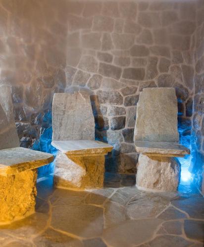 two stone benches sitting next to a stone wall at Residence Ciastel in Ortisei