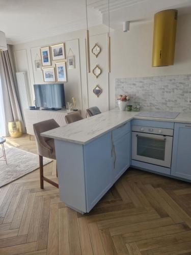 una cocina con una isla azul en una habitación en Serce miasta Gdansk apartament, en Gdansk