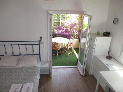 - une chambre avec un lit et une porte menant à une terrasse dans l'établissement B Appartement proche plage, centre, commerces, à Cavalaire-sur-Mer