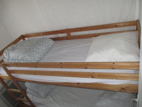 Ce lit superposé en bois se trouve dans un dortoir. dans l'établissement B Appartement proche plage, centre, commerces, à Cavalaire-sur-Mer
