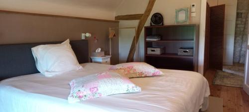 a bedroom with a bed with two pillows on it at Gîte et chambres d'hôtes Le Chêne Billault in Pouant