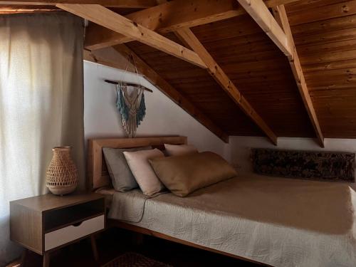 Cama en habitación con techo de madera en Jordan River Village, en Menaẖemya