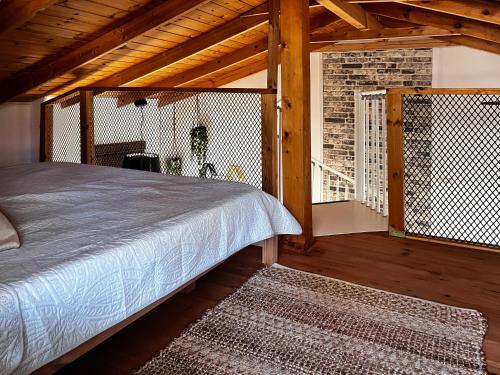 a bedroom with a bed and a balcony at Jordan River Village in Menaẖemya