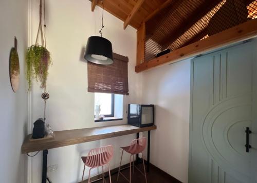 a kitchen with two pink chairs and a counter at Jordan River Village in Menaẖemya