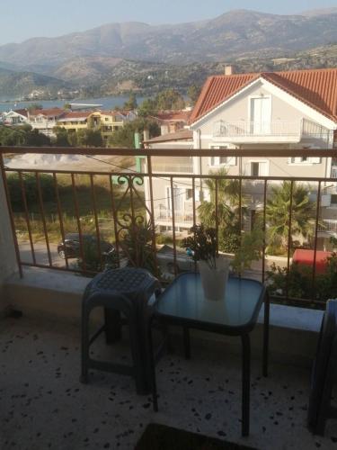 una mesa y una silla en un balcón con vistas en Argostoli Elia's Maisonette, en Argostoli