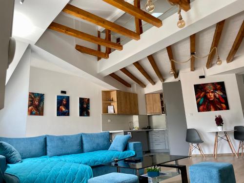 a living room with a blue couch and a table at Gallery City Center Apartment in Skopje