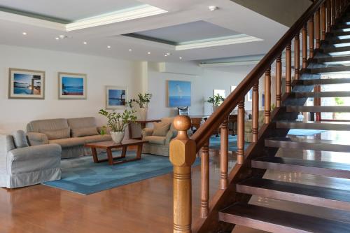 a living room with a staircase with a couch and a table at Elounda Beach Hotel & Villas, a Member of the Leading Hotels of the World in Elounda