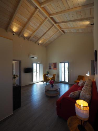 a living room with a red couch and a table at Terra Di Pietra Exclusive Suites & Apartments in Areopolis
