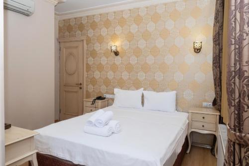 a bedroom with a white bed with two towels on it at Felicity Hotel İstanbul in Istanbul
