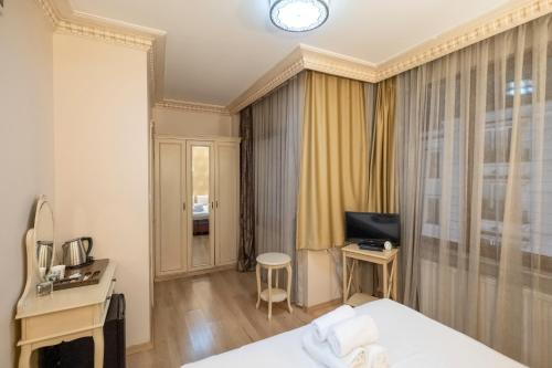 a hotel room with a bed and a desk and a television at Felicity Hotel İstanbul in Istanbul