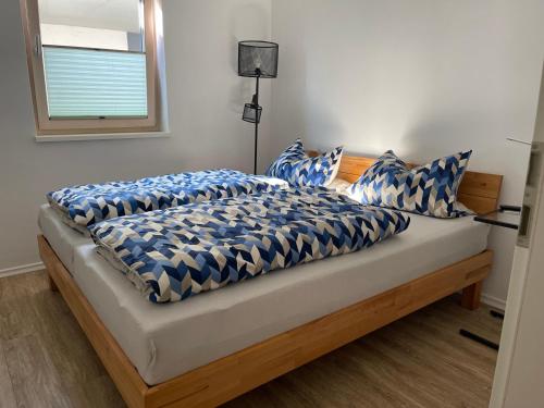 a bed with blue and white blankets and pillows on it at Ferienwohnung im wunderschönen Altmühltal in Wellheim