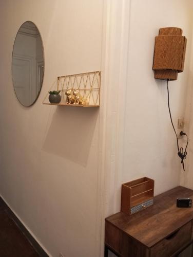a mirror and a shelf on a wall with a table at Appartement hyper centre 1 lorient Jardin clos in Lorient