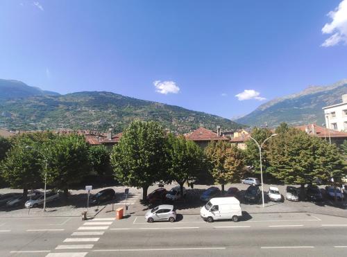 dos coches estacionados en un estacionamiento con una montaña en Up to 3 people - B Room shared bathroom - MyAostaProject Rentals en Aosta