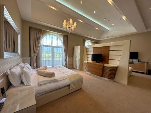 a large bedroom with a large bed and a television at Gabala Garden Hotel in Gabala