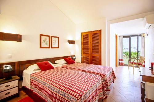 a bedroom with a bed with two red pillows at LOTUS VILLA 2, ALBUFEIRA in Albufeira